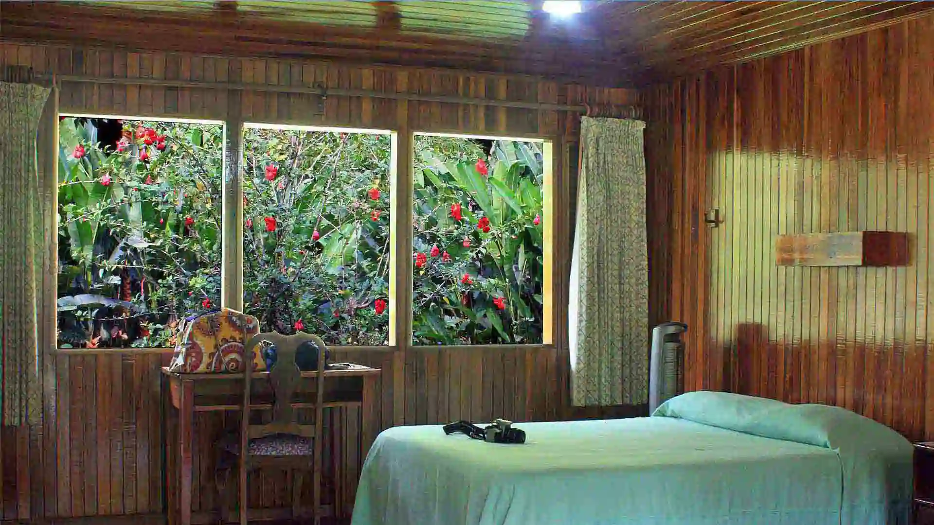 Wood-paneled Bedroom with Screened Window and Flowers